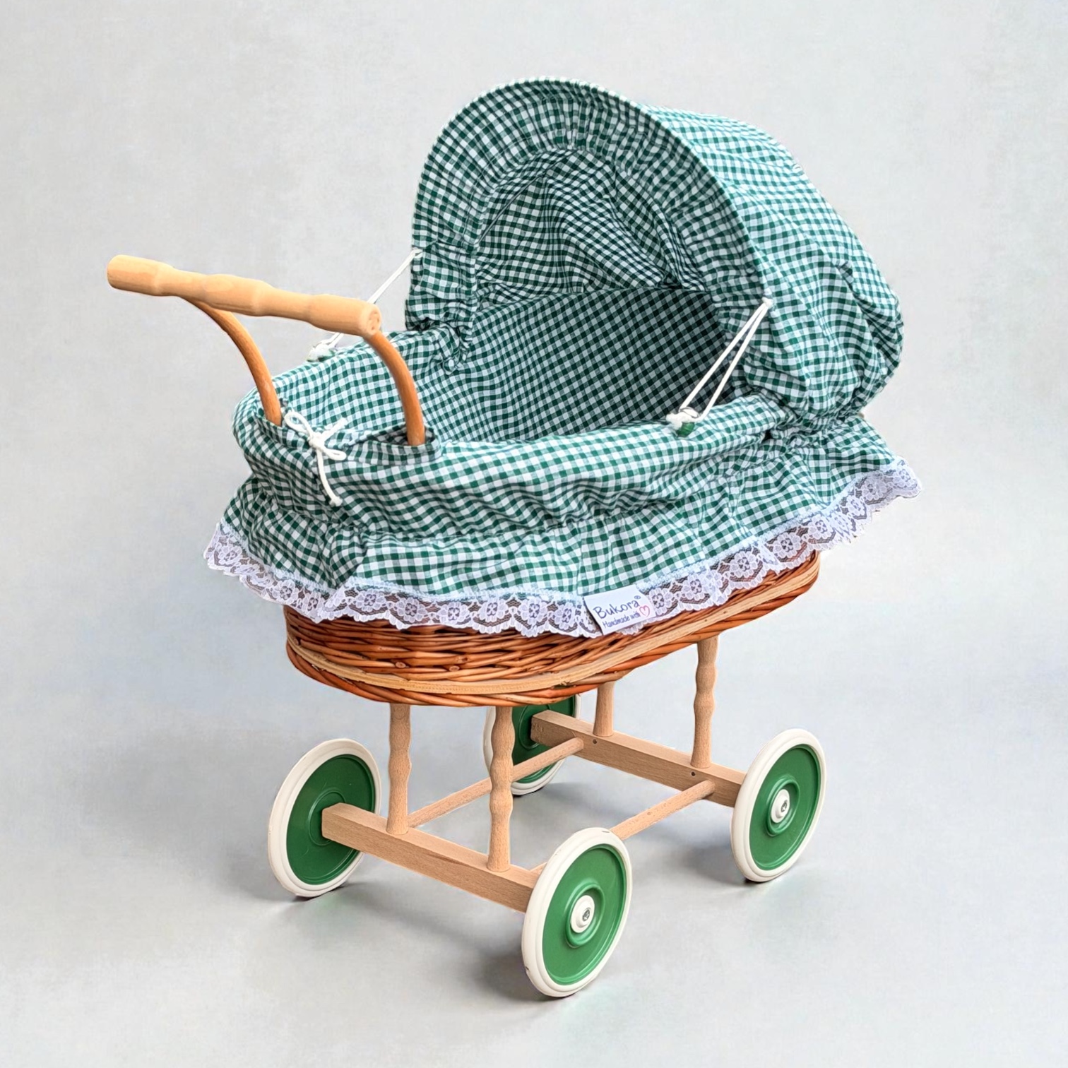 Freigestellter Puppenwagen aus Weide mit grün kariertem Stoff