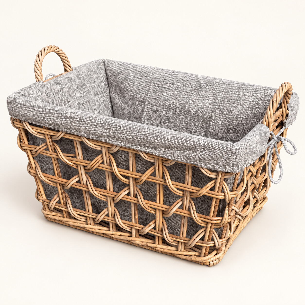 Rechteckiger Rattankorb Biggy in Kubo Grey mit offenem Flechtmuster, grauem Stoffinlett und zwei Tragegriffen, schräg von vorne.